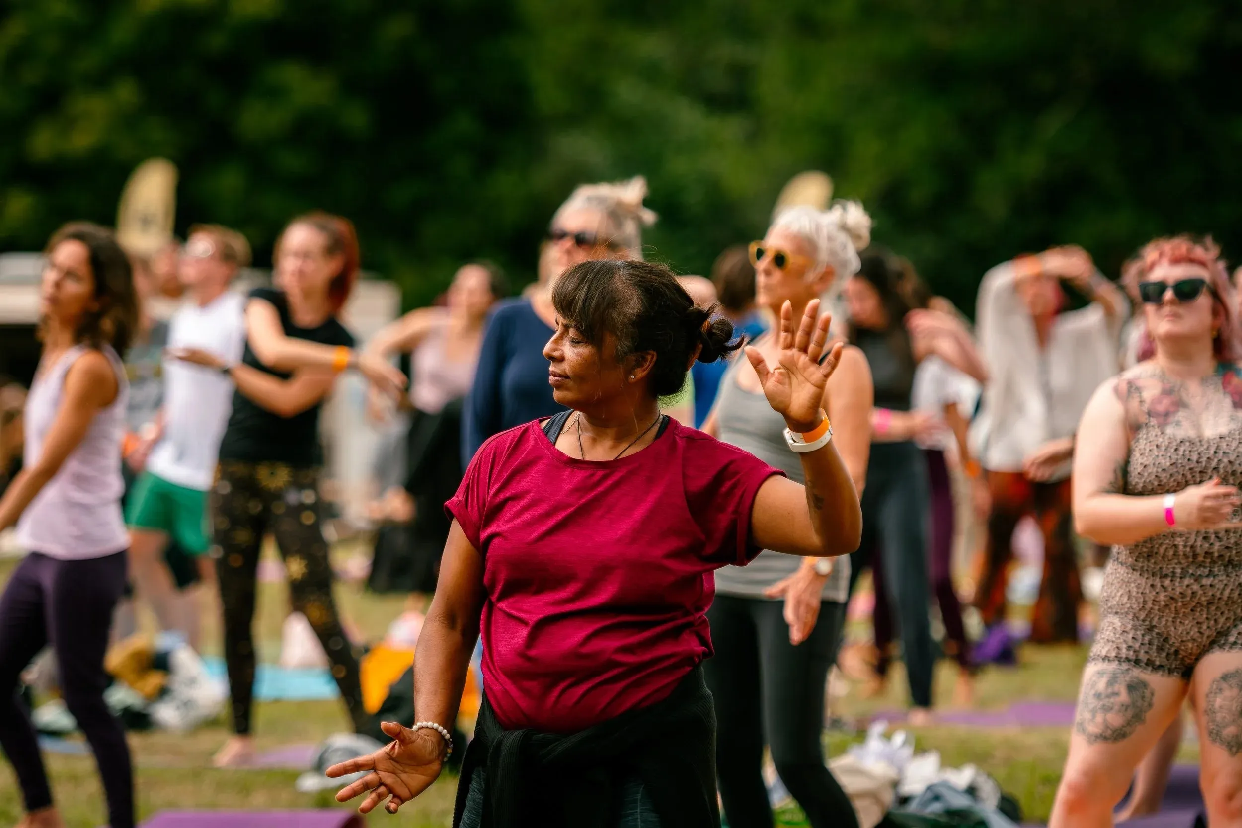 A woman in a red top dancing among the crowd, caught mid-movement.