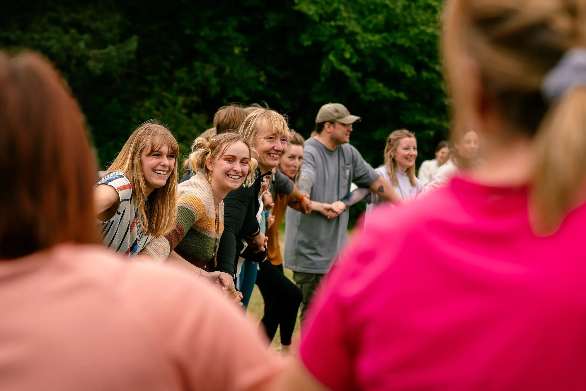 A group of women smiling together on the grass at the festival.