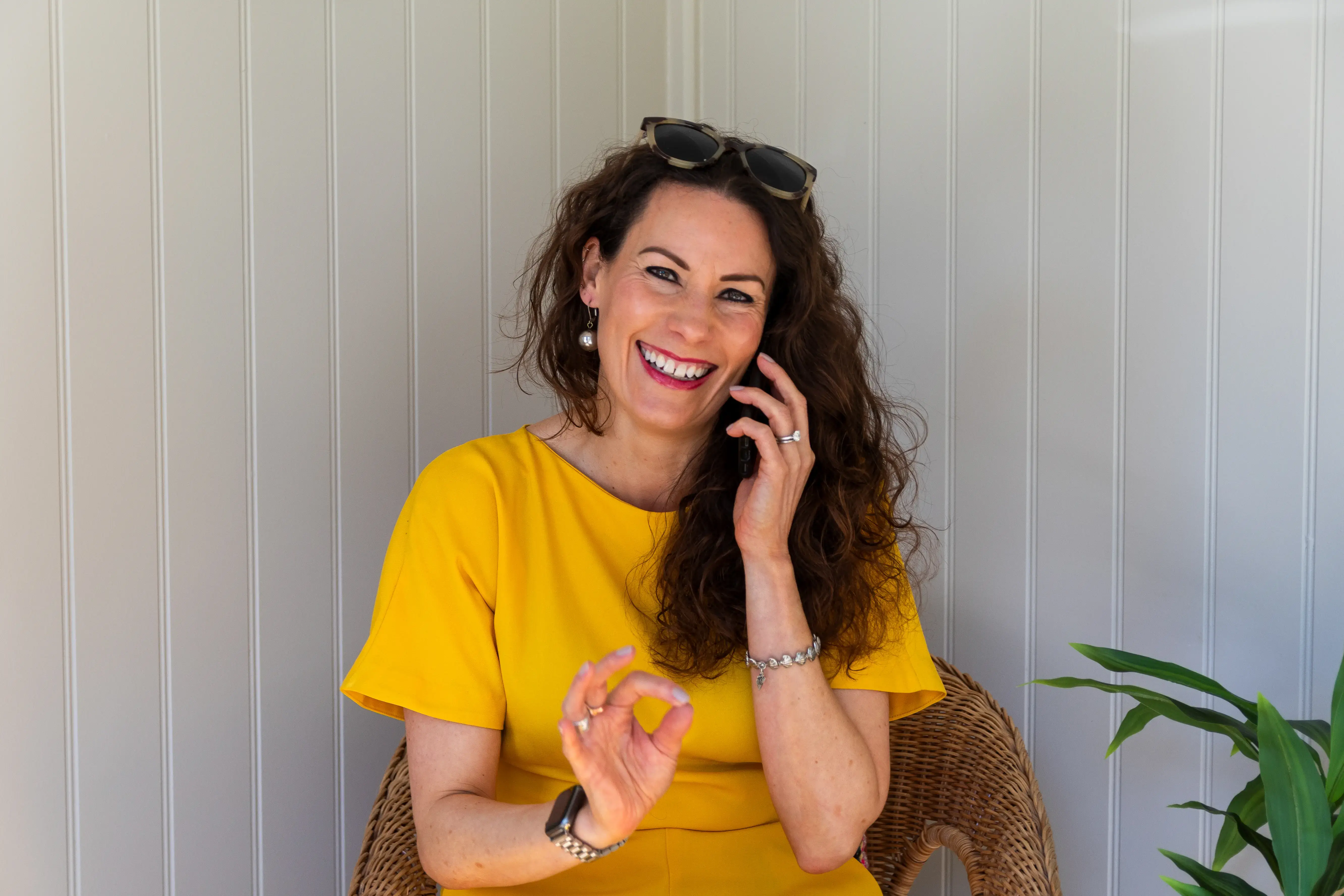 A woman in a yellow dress taking a phone call