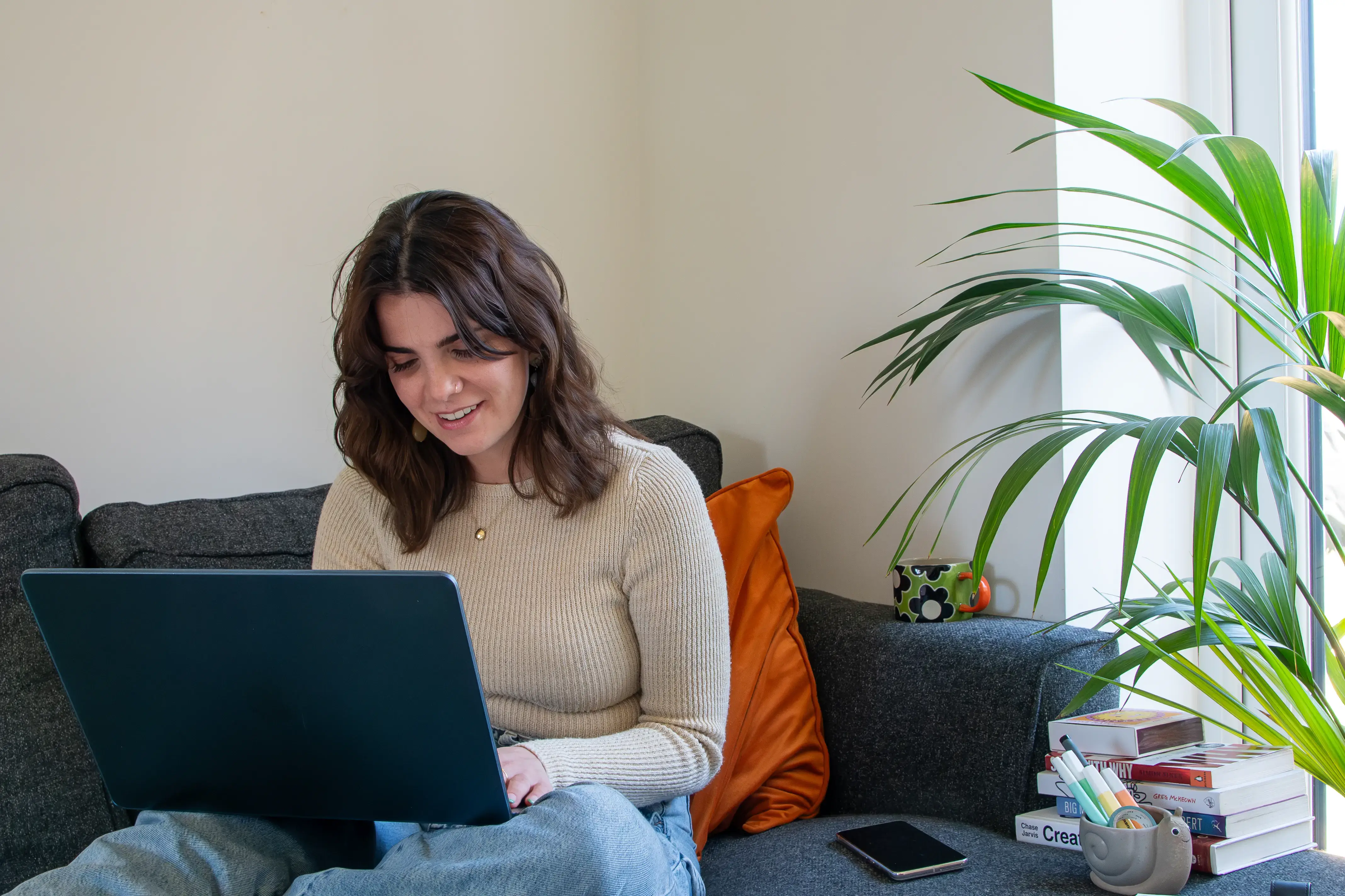 A female business owner working on her laptop at home